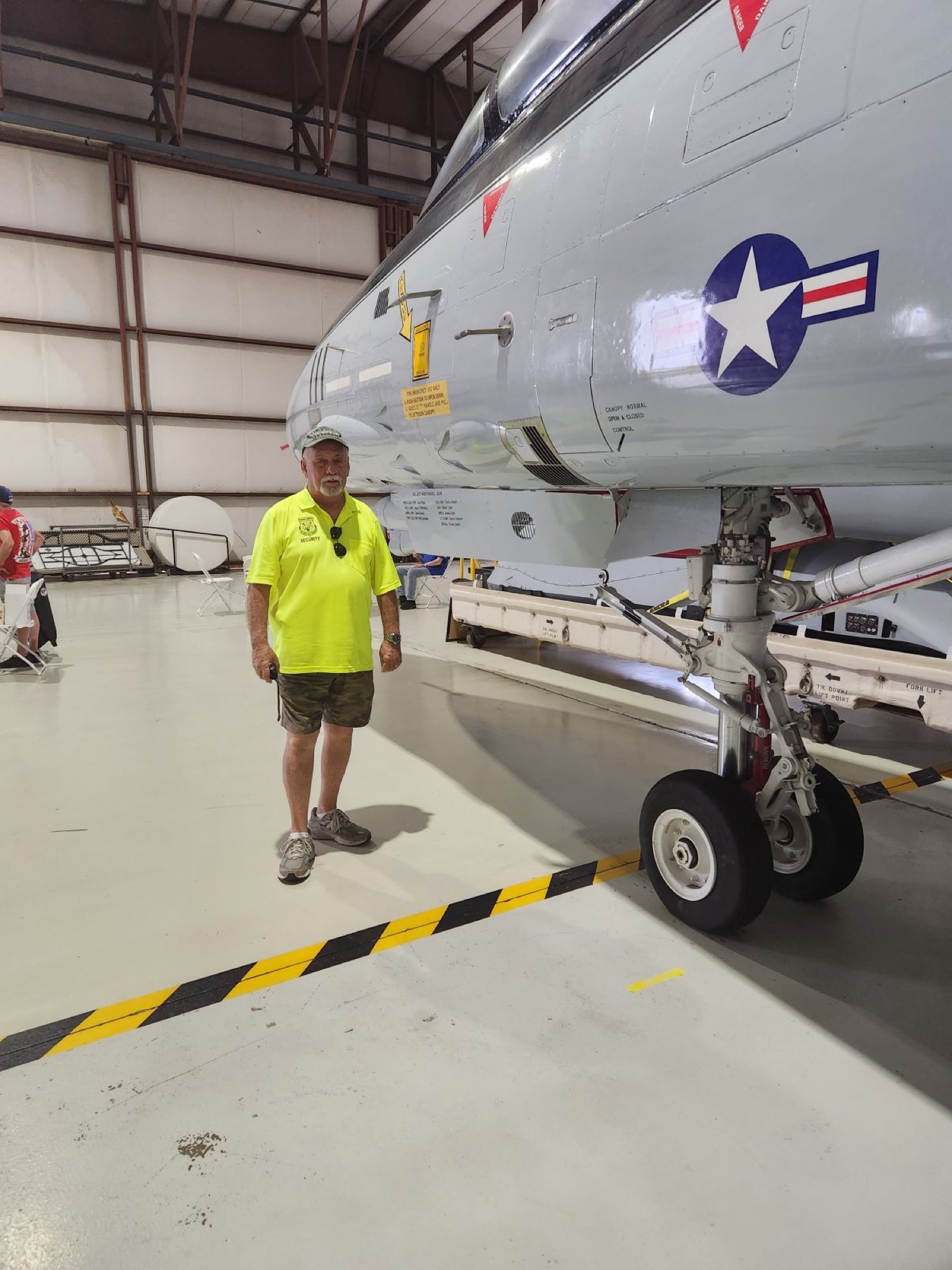 Larry Mathis standing beside an F-14 Tomcat at the Valiant Air Command Warbird Museum