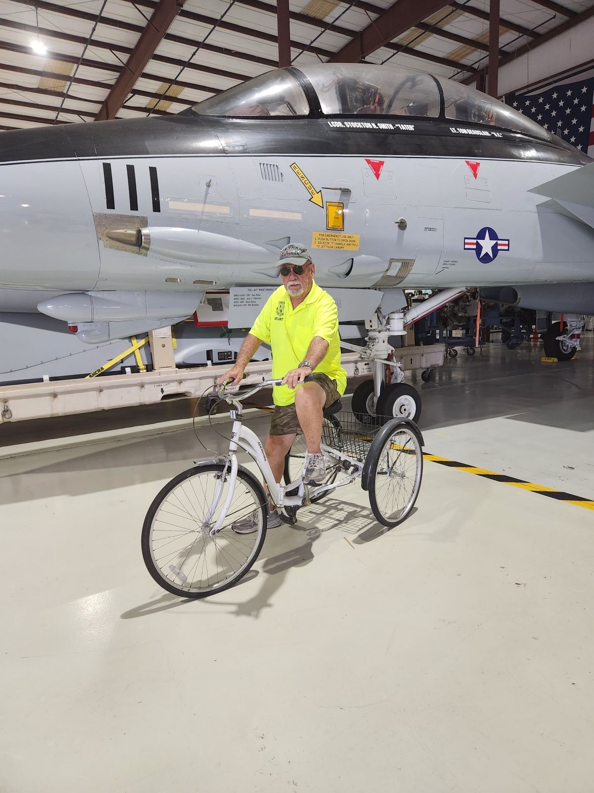 Larry on a tricycle in front of the F-14 Tomcat