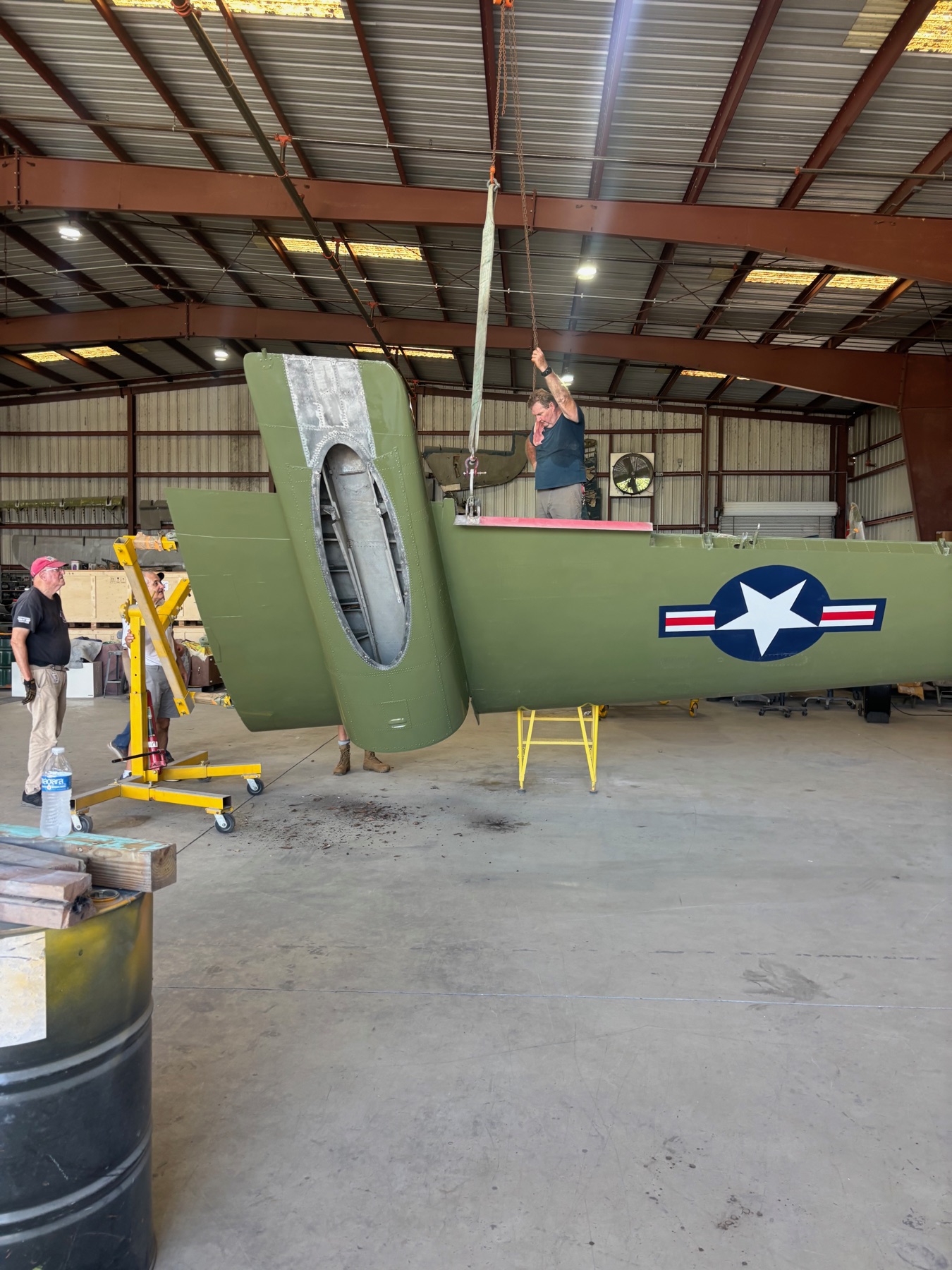 One of the OV-1 Mohawk wings being flipped during restoration, suspended by a crane